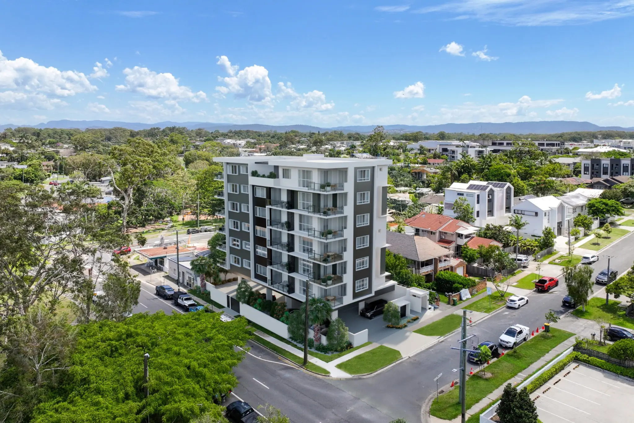 Property-development photomontage for 54 Falconer Street, Southport, presenting the proposed apartment building, balconies, landscaping, vehicle access and surrounding residential context. Aerial architectural photomontage of a contemporary apartment development at 54 Falconer Street in Southport integrated into the existing neighbourhood